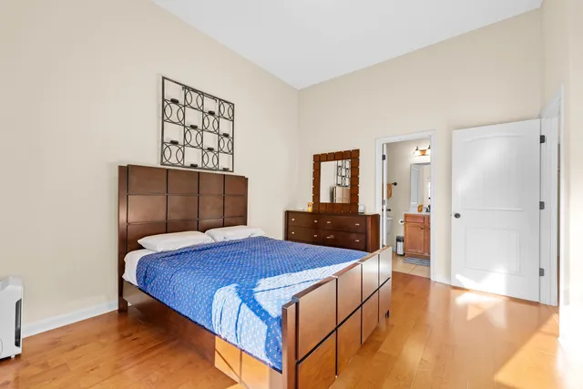 a bedroom with a bed and wooden floor