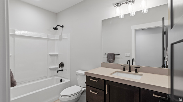 355 East Overlook Loop Hideout, UT 84036 - Photo 33 of 40 One of two lower level bathrooms featuring a white tub/shower combination with matte black fixtures, a white toilet, and a vanity with a light-colored countertop and dark wood-finish cabinetry