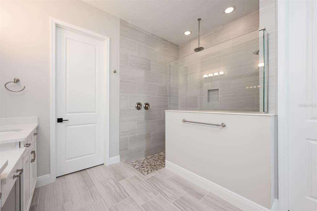 15714 Vetta Drive Montverde, FL 34756 - Photo 16 of 45 a bathroom with a glass shower door and a sink