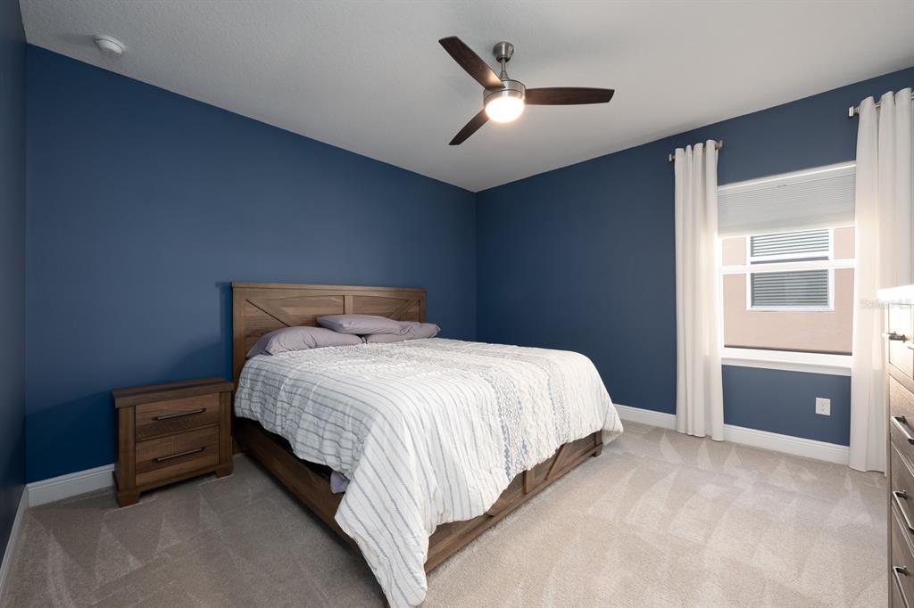 15714 Vetta Drive Montverde, FL 34756 - Photo 26 of 45 a bedroom with a bed and a chandelier