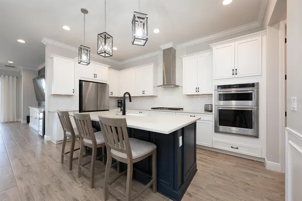 a kitchen with a table chairs microwave and cabinets