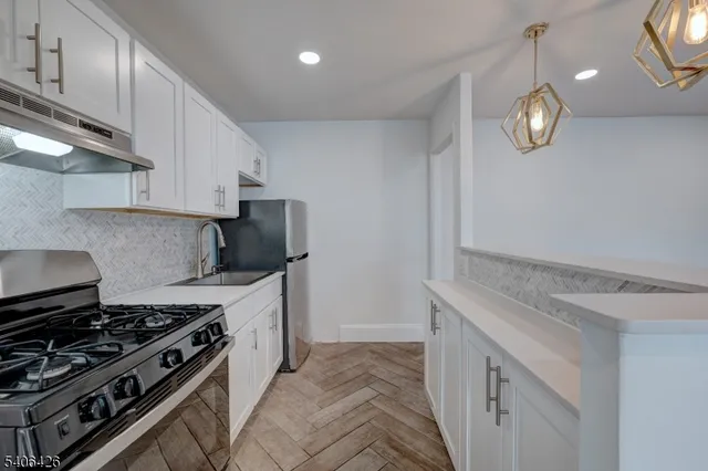 a kitchen with granite countertop a stove and a sink