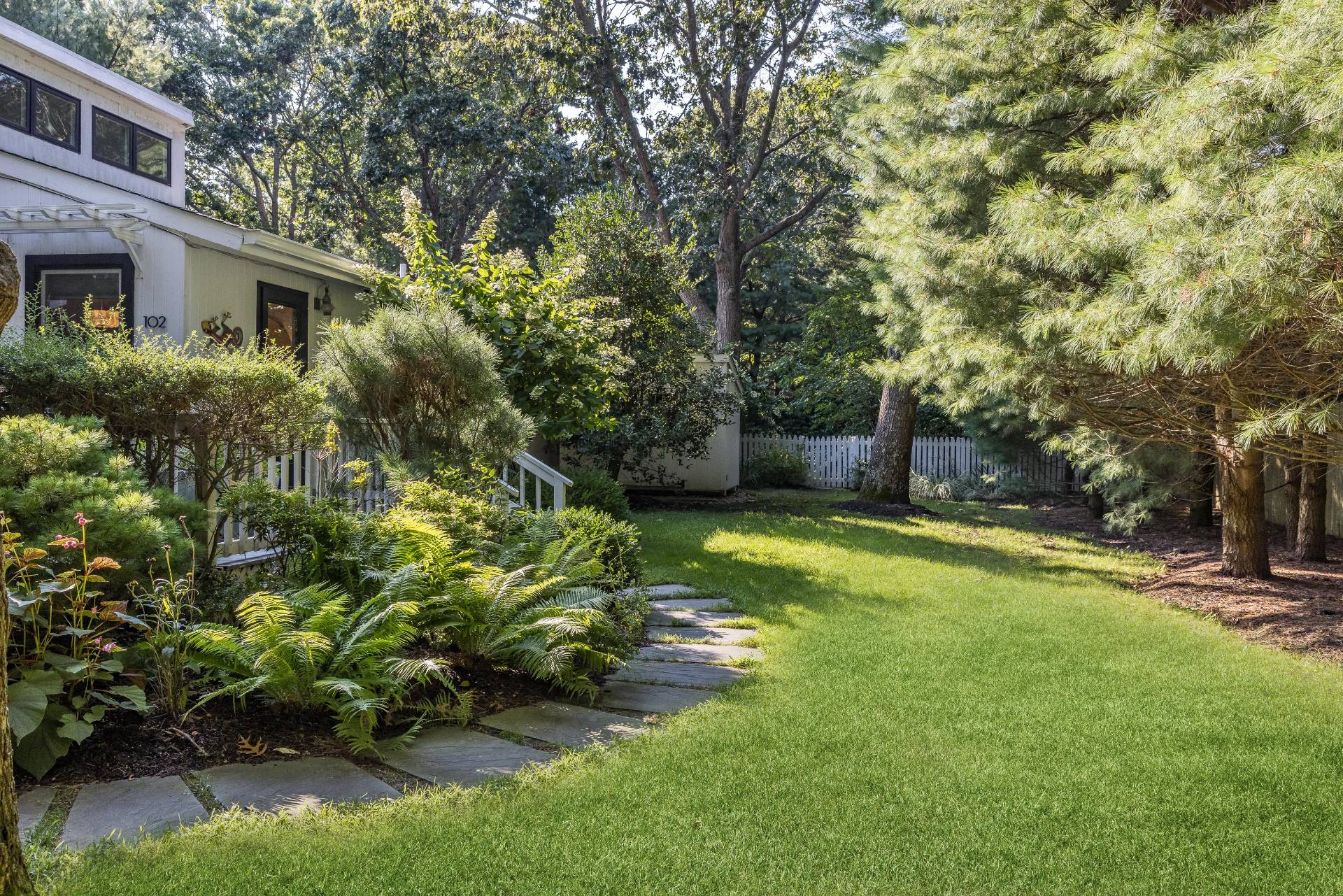 102 Rutland Road East Hampton, NY 11937 - Photo 18 of 20 a view of a backyard with plants and large trees