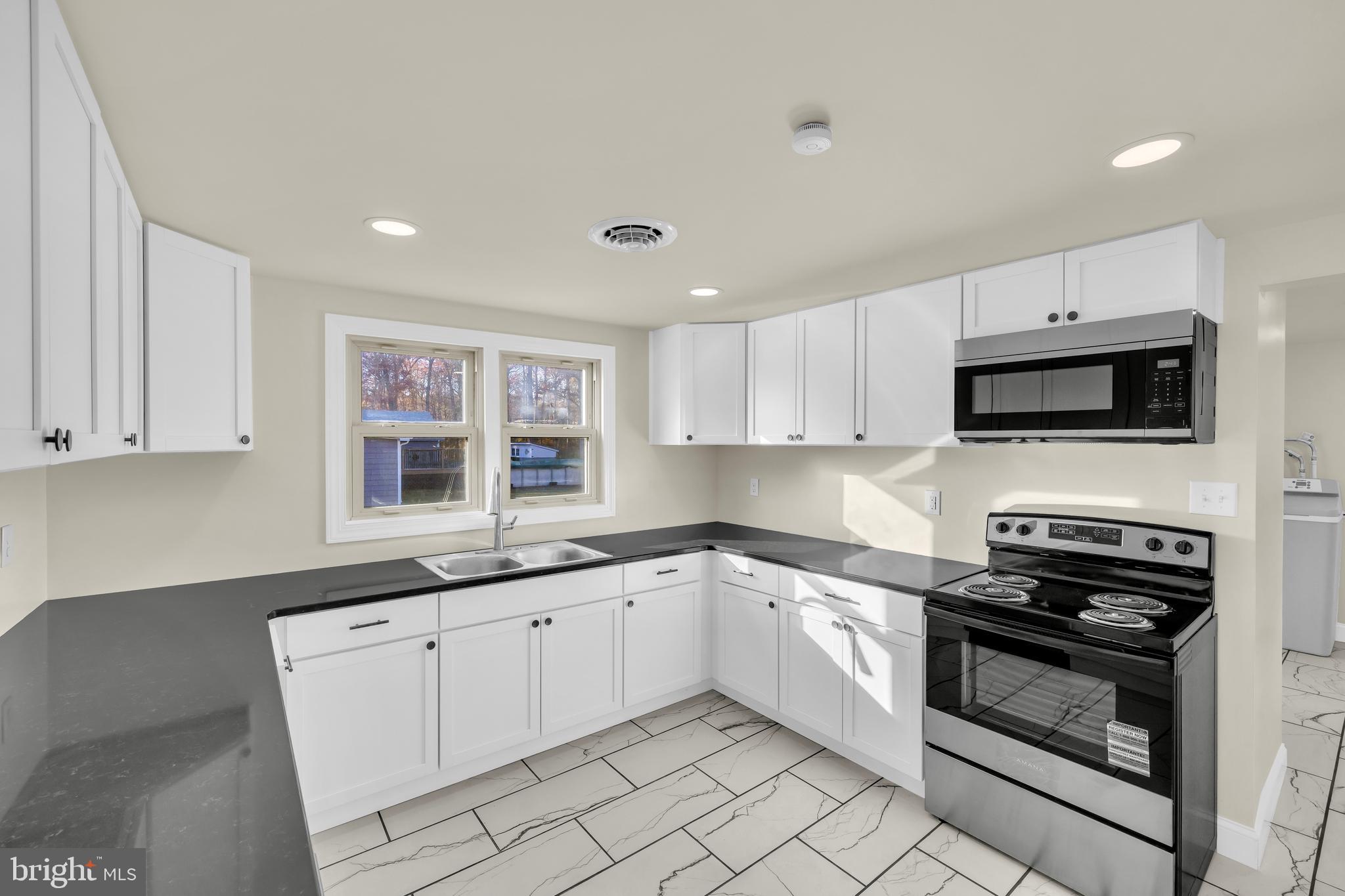 334 Deep Shore Road Denton, MD 21629 - Photo 30 of 48 a kitchen with white cabinets stainless steel appliances and a sink