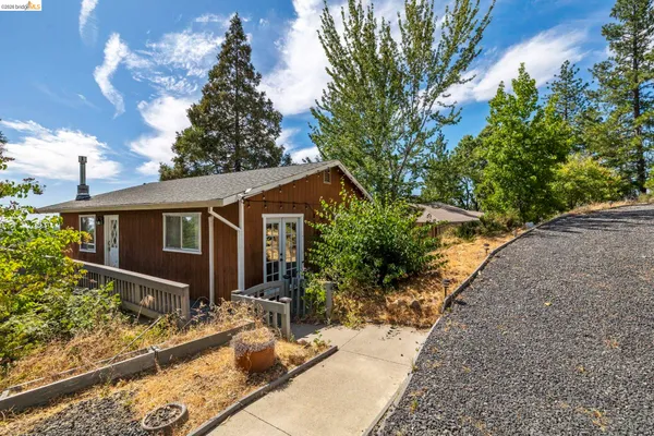 a front view of house with yard and trees around