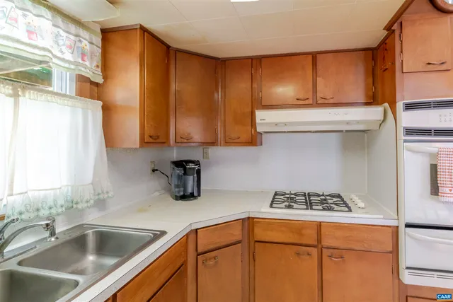 a kitchen with stainless steel appliances granite countertop a sink stove and cabinets