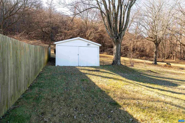 a view of a house with a large tree and a yard