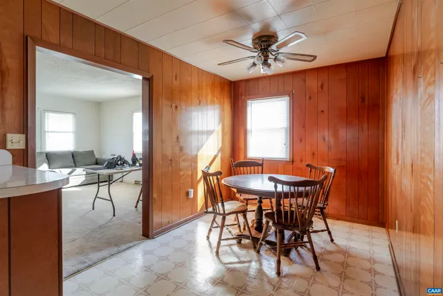 a view of a dining room with furniture and a chandelier fan