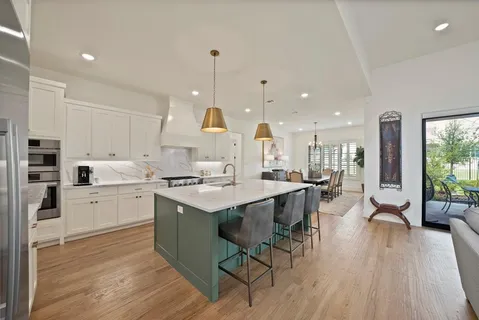 a kitchen with white cabinets stove and center island