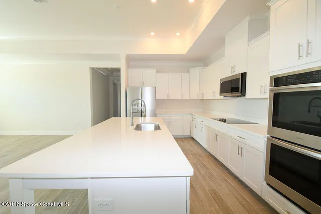a kitchen with a sink a microwave and cabinets