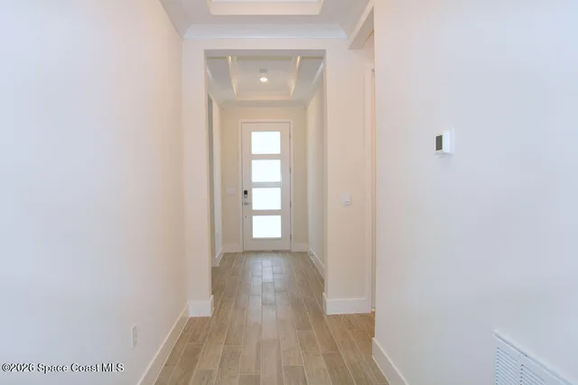 a view of a room with wooden floor and a bathroom