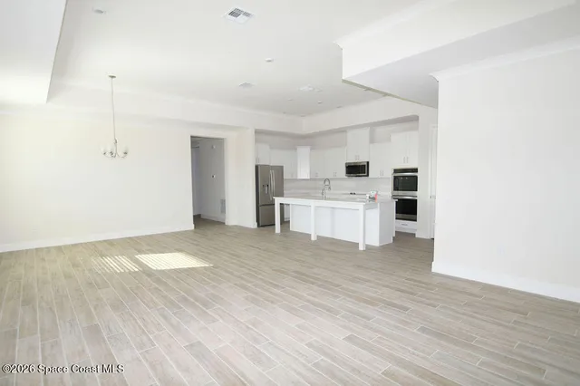 a view of a kitchen with a sink and white cabinets