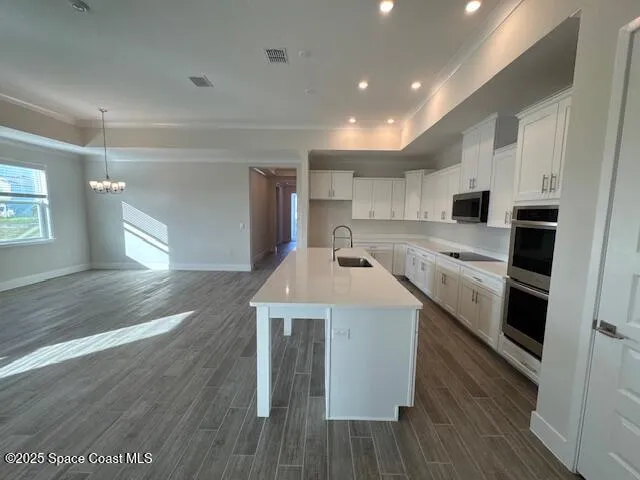 a view of a kitchen with wooden floor and a window