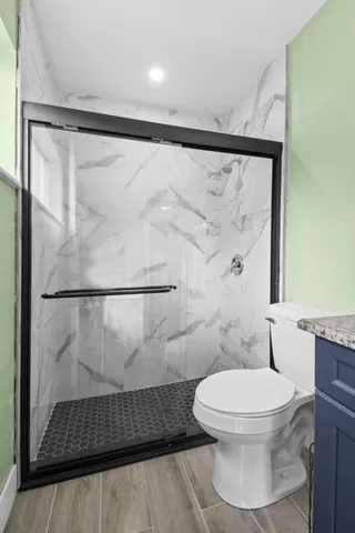 a white toilet sitting next to a shower