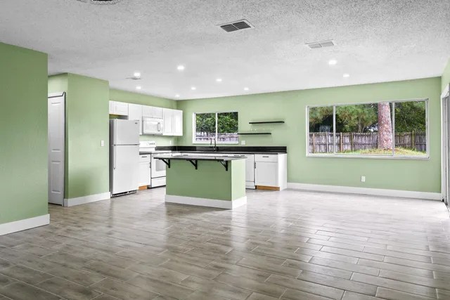 a kitchen with kitchen island stainless steel appliances granite countertop a sink and a stove top oven