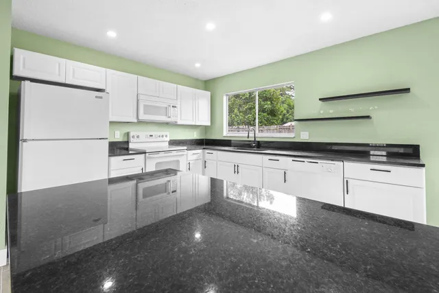 a kitchen with white cabinets and white appliances