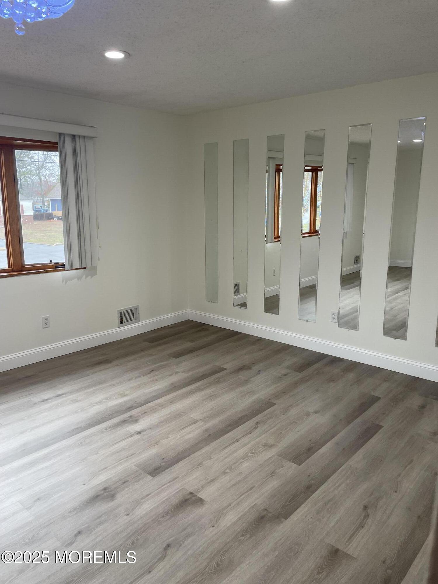 69 Mallard Road Bayville, NJ 08721 - Photo 7 of 21 an empty room with wooden floor and windows