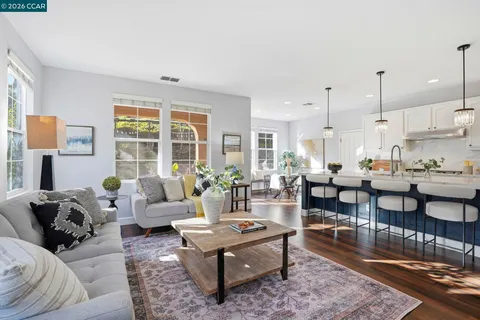 a kitchen with stainless steel appliances kitchen island a table chairs refrigerator and sink