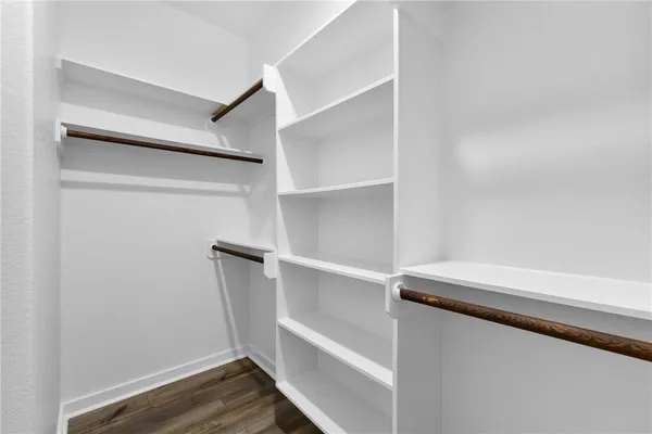a view of a kitchen with white cabinets and wooden floor