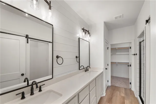 a bathroom with a double vanity sink a mirror and a shower