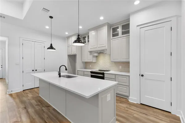 a kitchen with stainless steel appliances granite countertop a sink and a stove