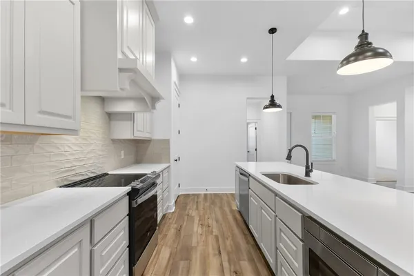 a view of a kitchen counter space a sink and wooden floor