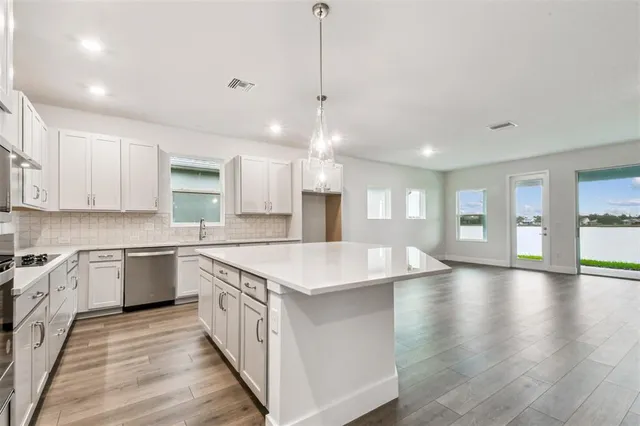 a kitchen with stainless steel appliances granite countertop white cabinets a sink and dishwasher