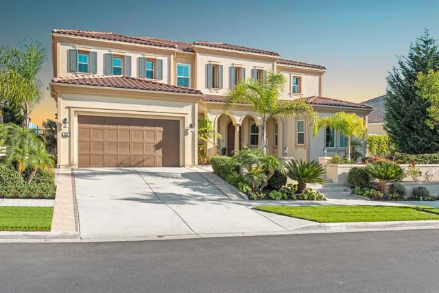 a front view of a house with a yard and potted plants