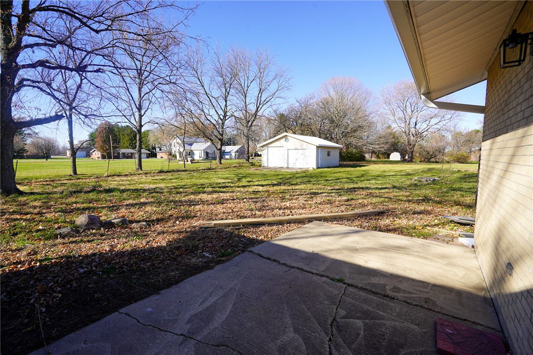 8746 Grubbs-Rex Road Arcanum, OH 45304 - Photo 25 of 38 This spacious yard features a concrete patio, a detached garage, and a lush green lawn.