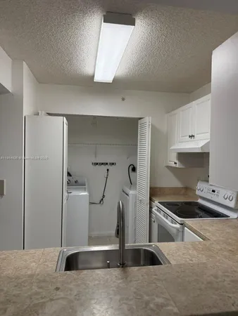 a kitchen with stainless steel appliances kitchen island a sink stove and refrigerator