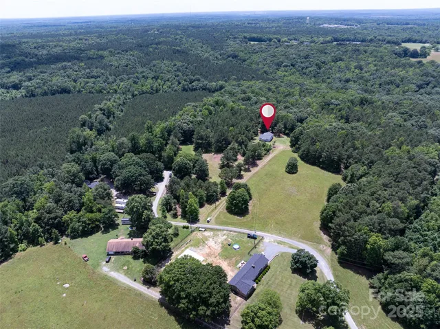 an aerial view of a house with a yard and street
