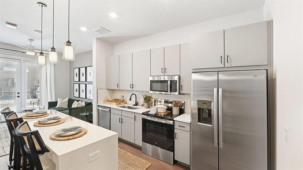 1735 North Greenville Avenue, Unit 2228 Richardson, TX 75081 - Photo 1 of 1 a kitchen with a refrigerator a stove a sink dishwasher a oven with white cabinets and wooden floor