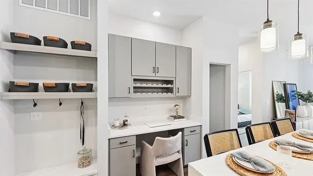 a kitchen with stainless steel appliances a white table and chairs in it