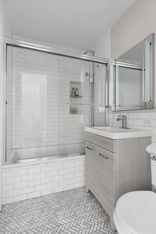 a bathroom with a sink a toilet and shower