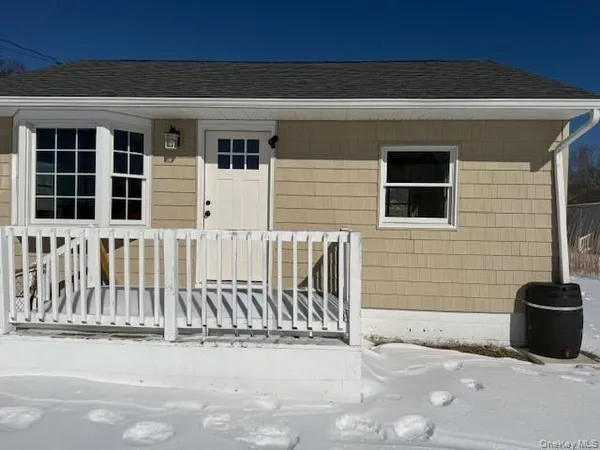 a view of a house with a small yard and wooden floor and fence