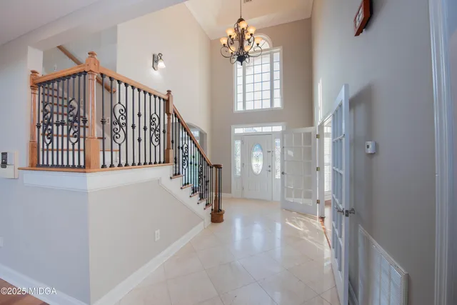 a view of a big room with windows and chandelier fan