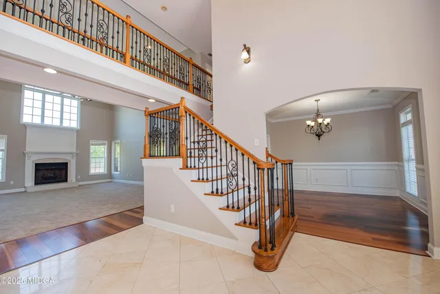 a view of a hallway with wooden floor and staircase