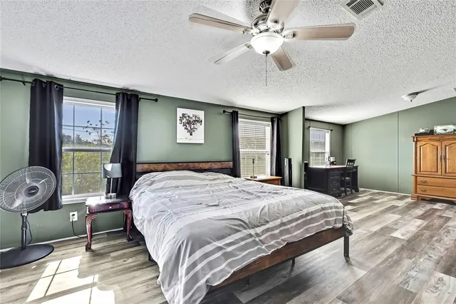 a spacious bedroom with a bed and a flat screen tv