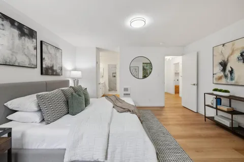 a bedroom with a bed and painting on the wall