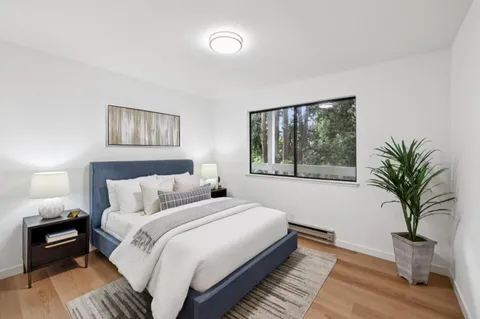 a bedroom with a large bed and a potted plant