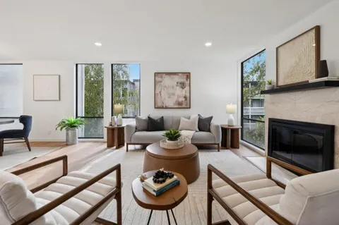 a living room with furniture a large window and a fireplace