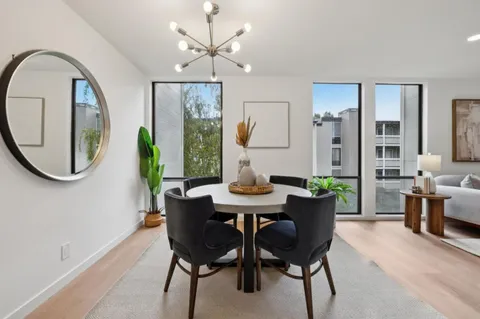 a view of a dining room with furniture a chandelier and wooden floor
