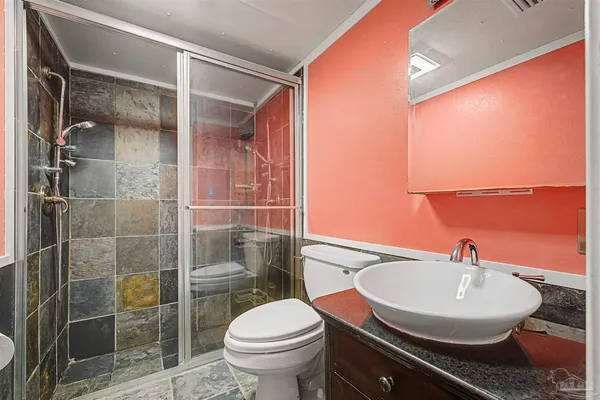 a bathroom with a sink a toilet and shower