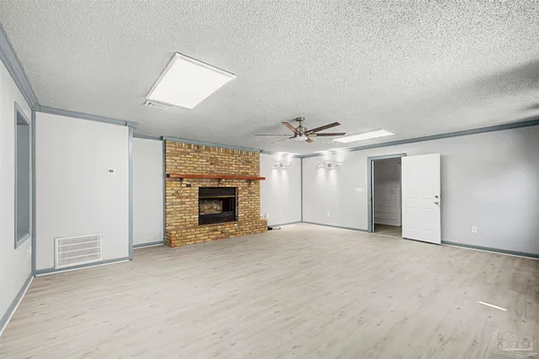 an empty room with fireplace and windows