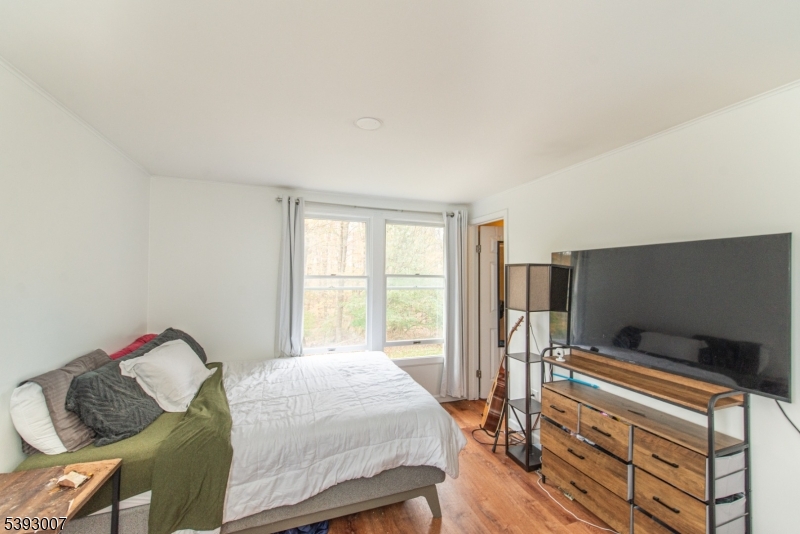 76 Constitution Way, Unit 76 Franklin, NJ 07416 - Photo 14 of 22 a bedroom with a bed and a flat screen tv