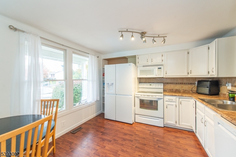 76 Constitution Way, Unit 76 Franklin, NJ 07416 - Photo 3 of 22 a kitchen with granite countertop a stove top oven sink and cabinets