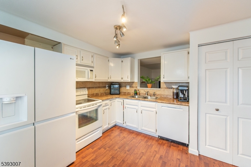 76 Constitution Way, Unit 76 Franklin, NJ 07416 - Photo 5 of 22 a kitchen with white cabinets and white appliances