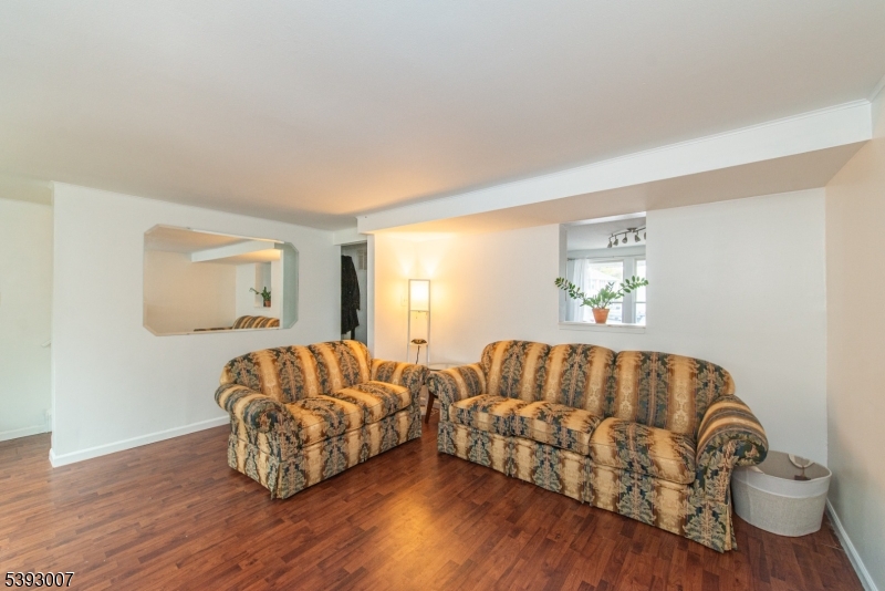 76 Constitution Way, Unit 76 Franklin, NJ 07416 - Photo 7 of 22 a living room with furniture and a wooden floor