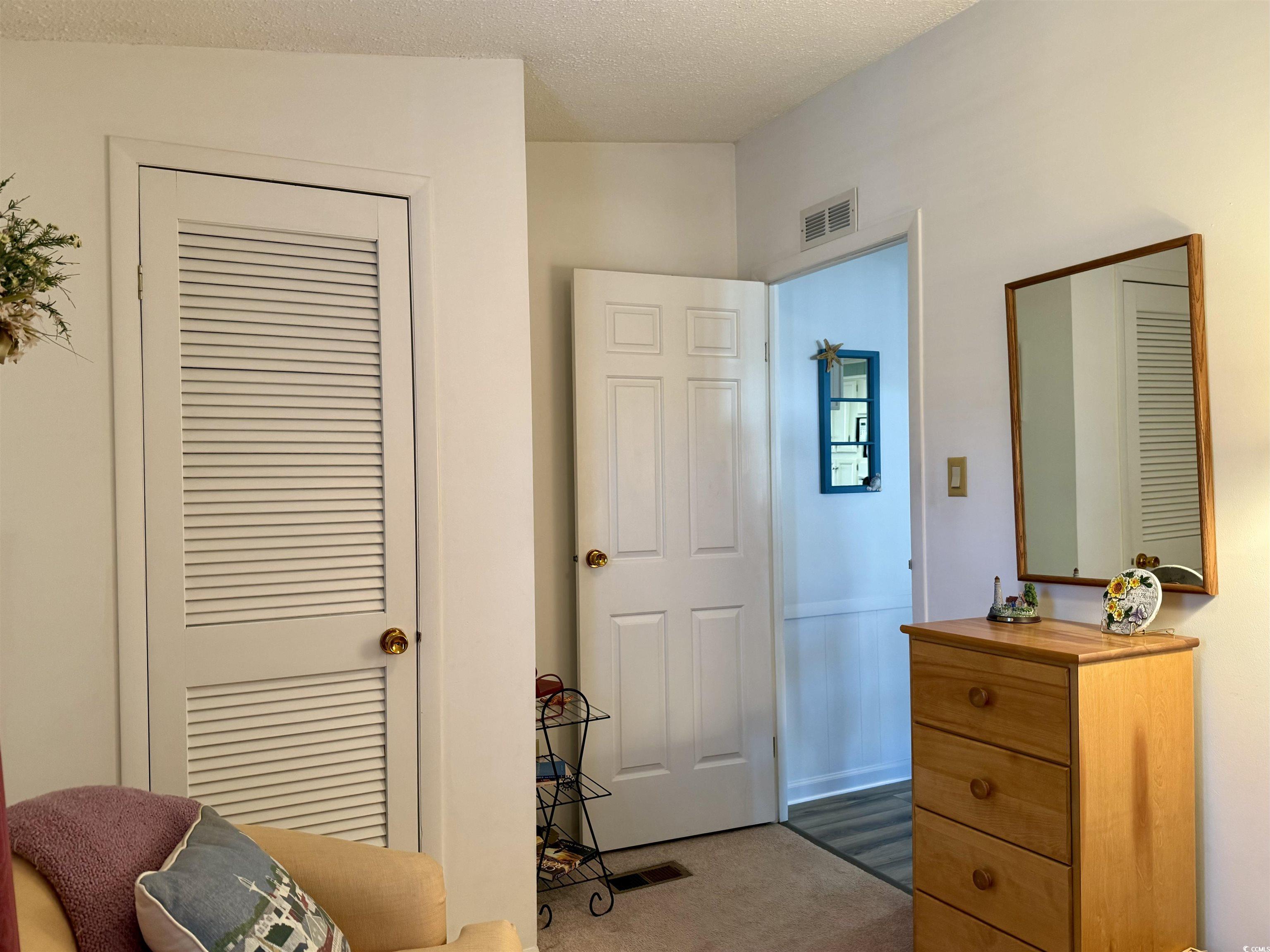 502 Sandpebble Surfside Beach, SC 29575 - Photo 13 of 31 Bedroom with dark carpet, vaulted ceiling, and a t