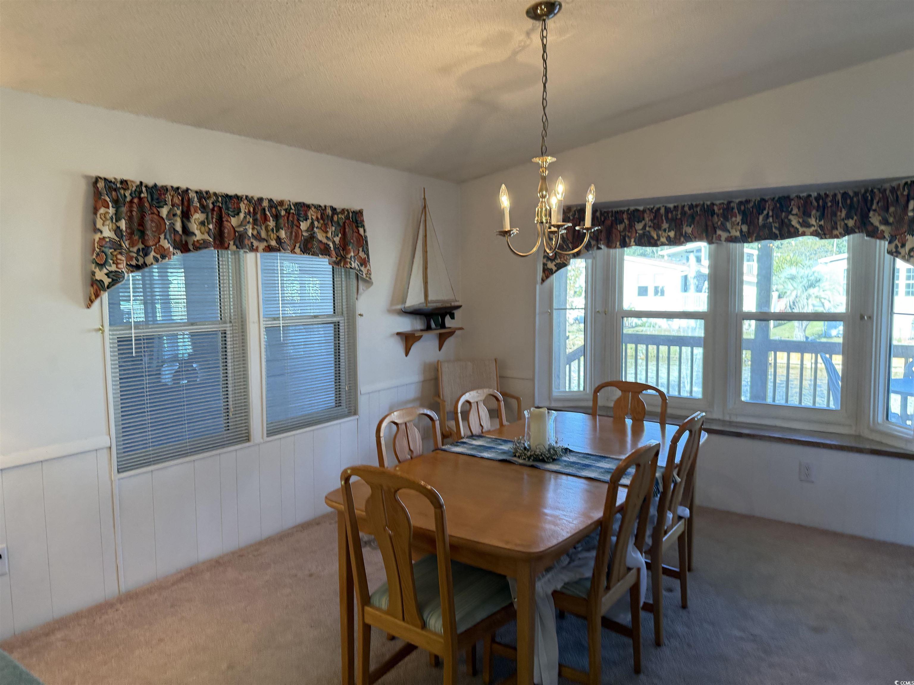 Carpeted dining room featuring a notable chandelie